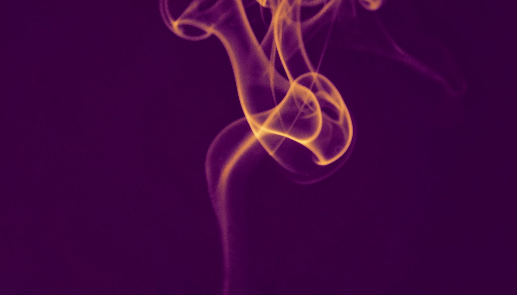 Duotone photograph in deep violet and soft gold, showing an abstract swirl of incense smoke rising against a dark background, the curves suggesting breath and meditative flow.